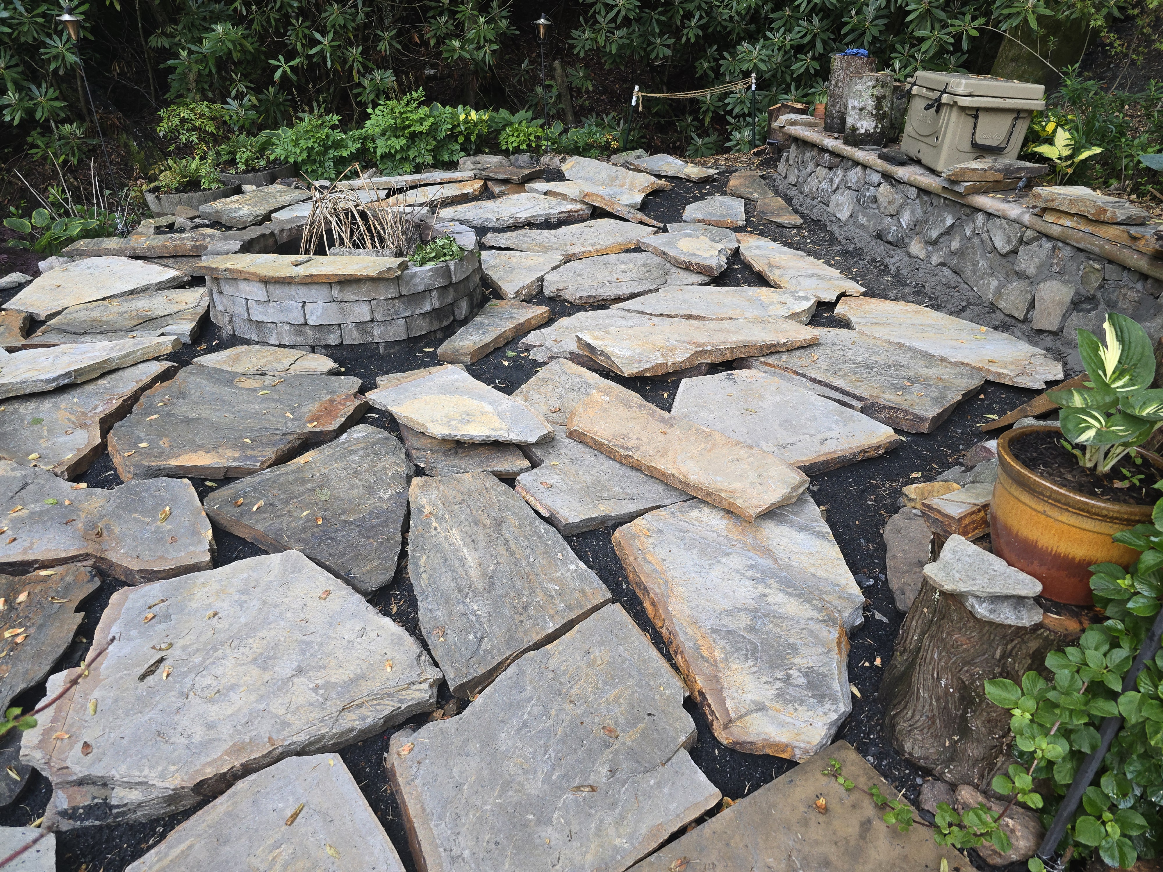 Patio build in progress — flagstone laid out over a gravel base
